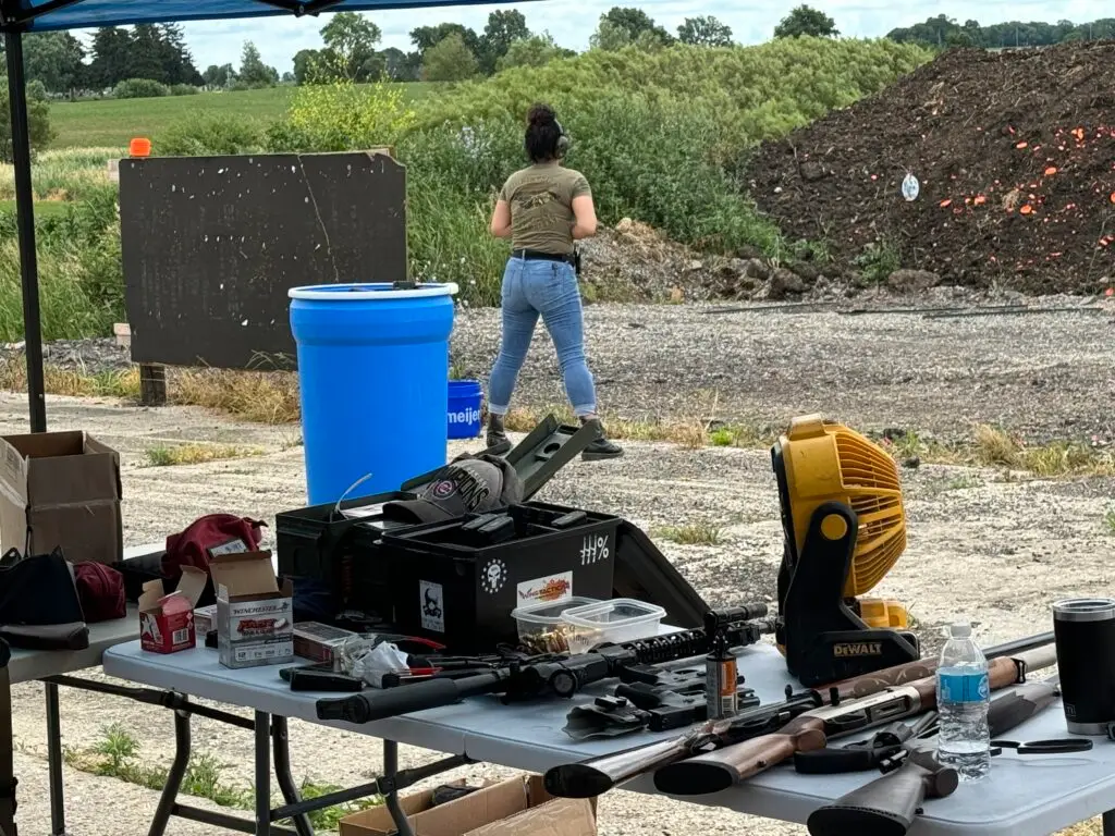 Outdoor shooting range with a shooter downrange and equipment on a table